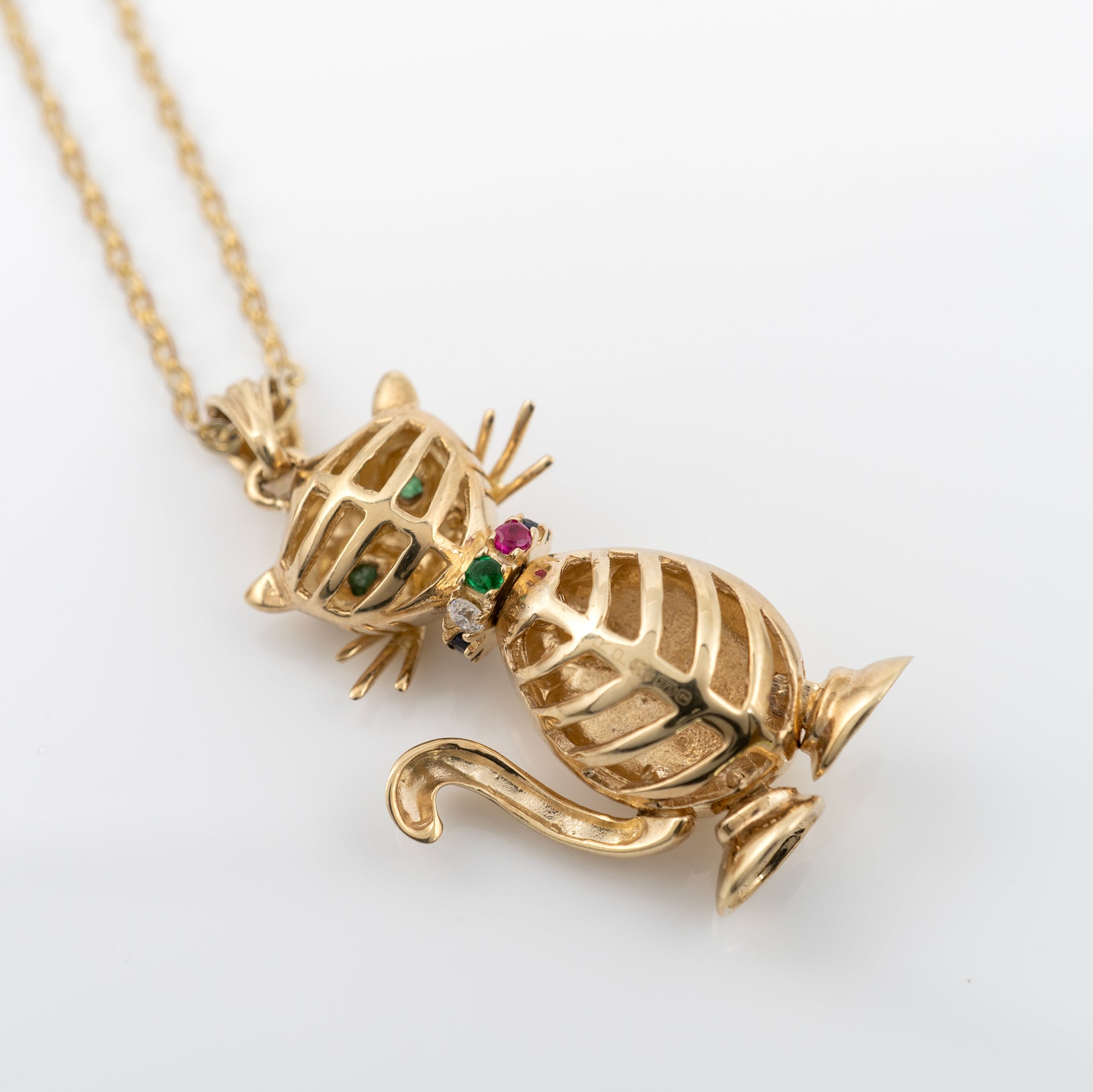 Gold cat pendant with gemstones