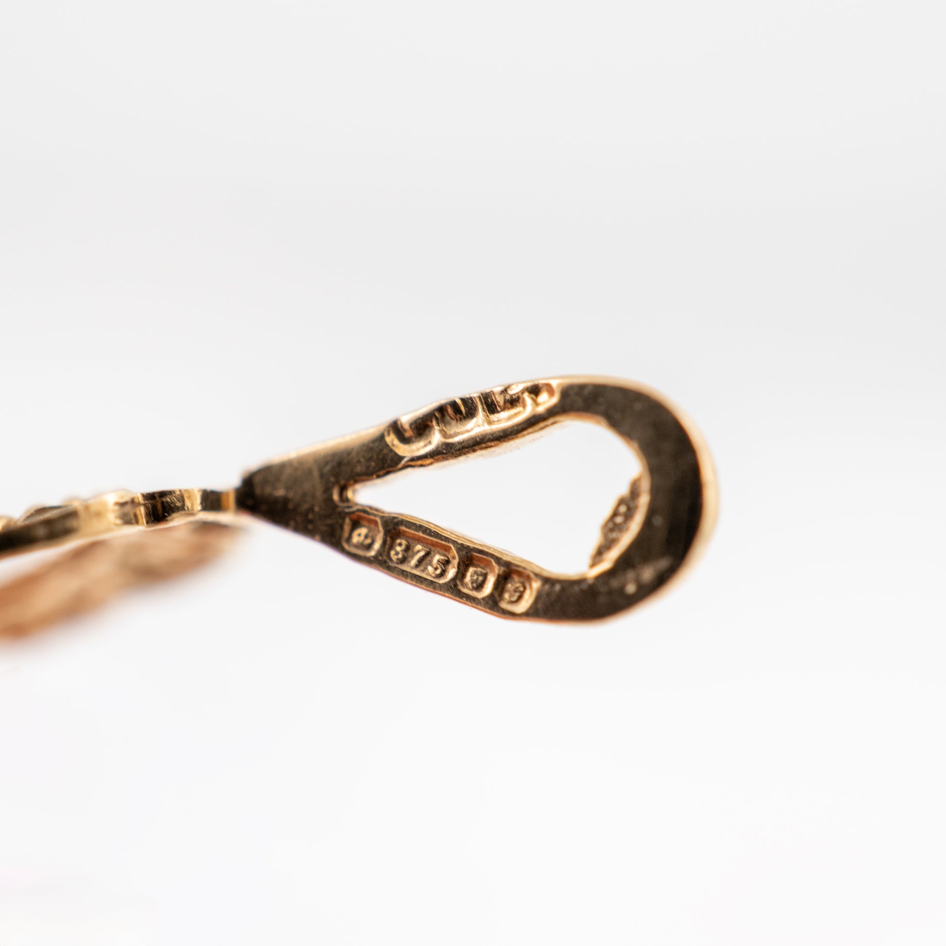 gold assay hallmarks on a pendant bail close up