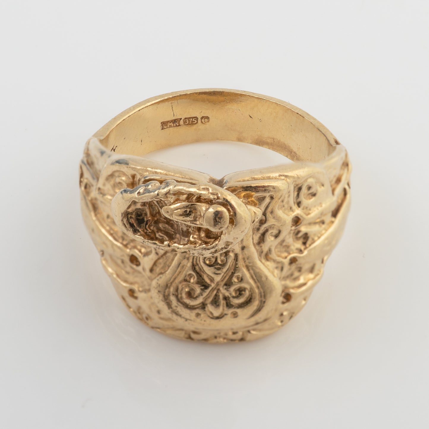 Hallmarks inside a vintage men's 9ct gold saddle ring showing the 375 gold mark and Birmingham assay marks.