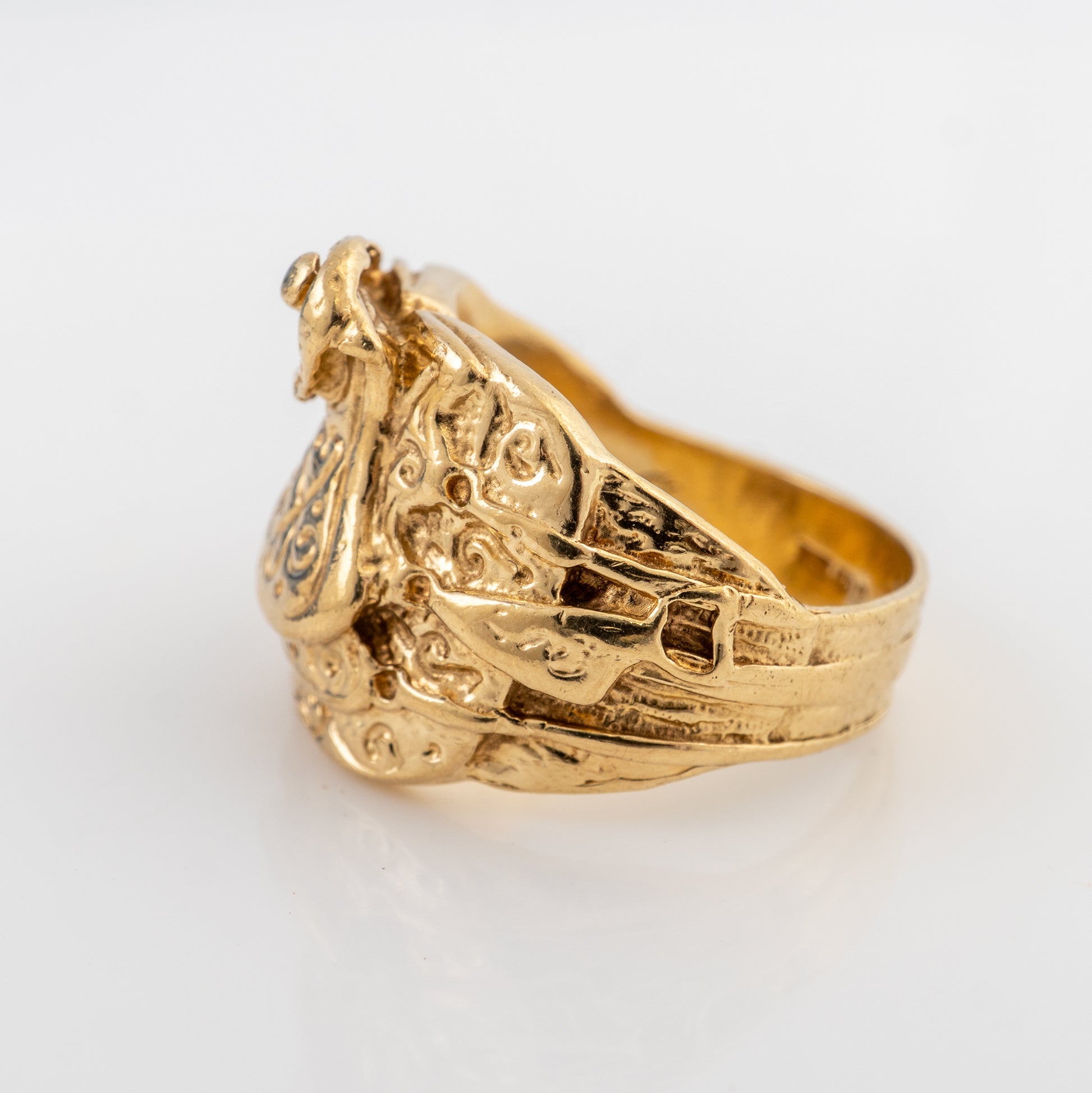 Vintage men's 9ct gold saddle ring showing the ornate shoulder detail and raised serpent design in yellow gold.