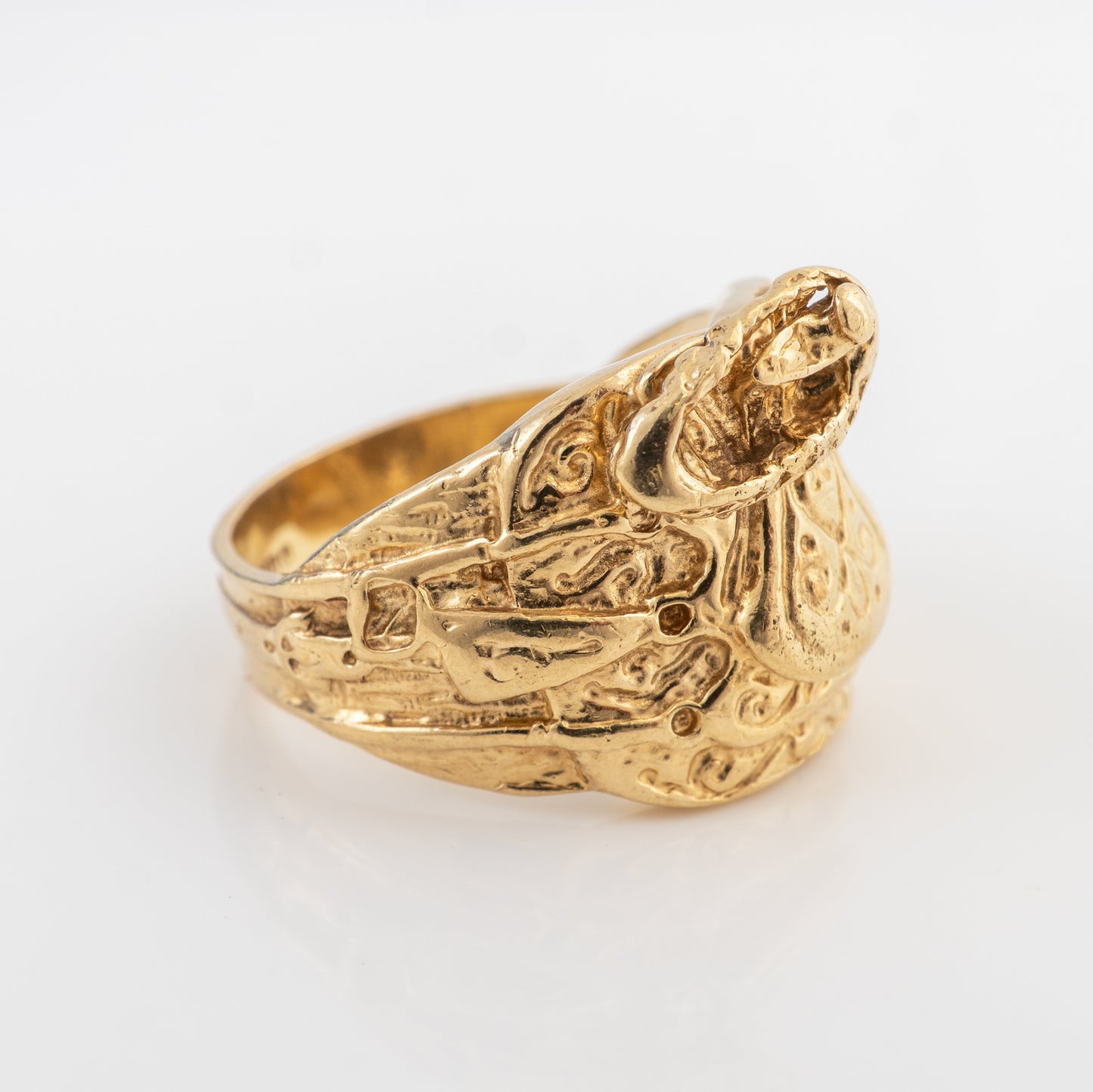 Side profile of a vintage men's 9ct gold saddle ring featuring ornate scrollwork and a raised serpent design.