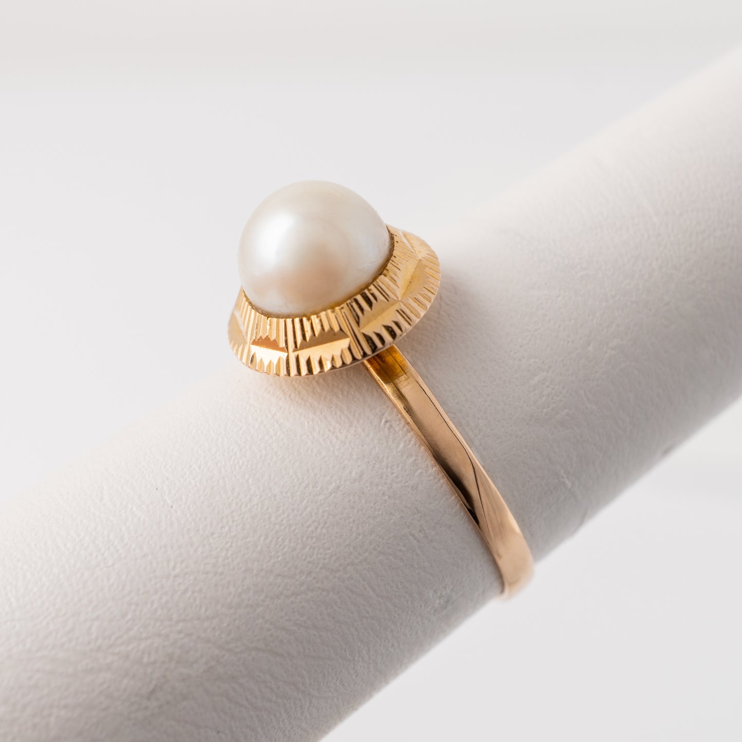 Angled view highlighting the pearl and engraved detail on vintage ring