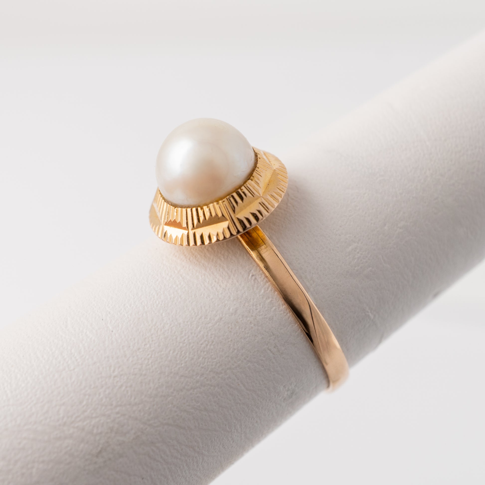 Angled view highlighting the pearl and engraved detail on vintage ring