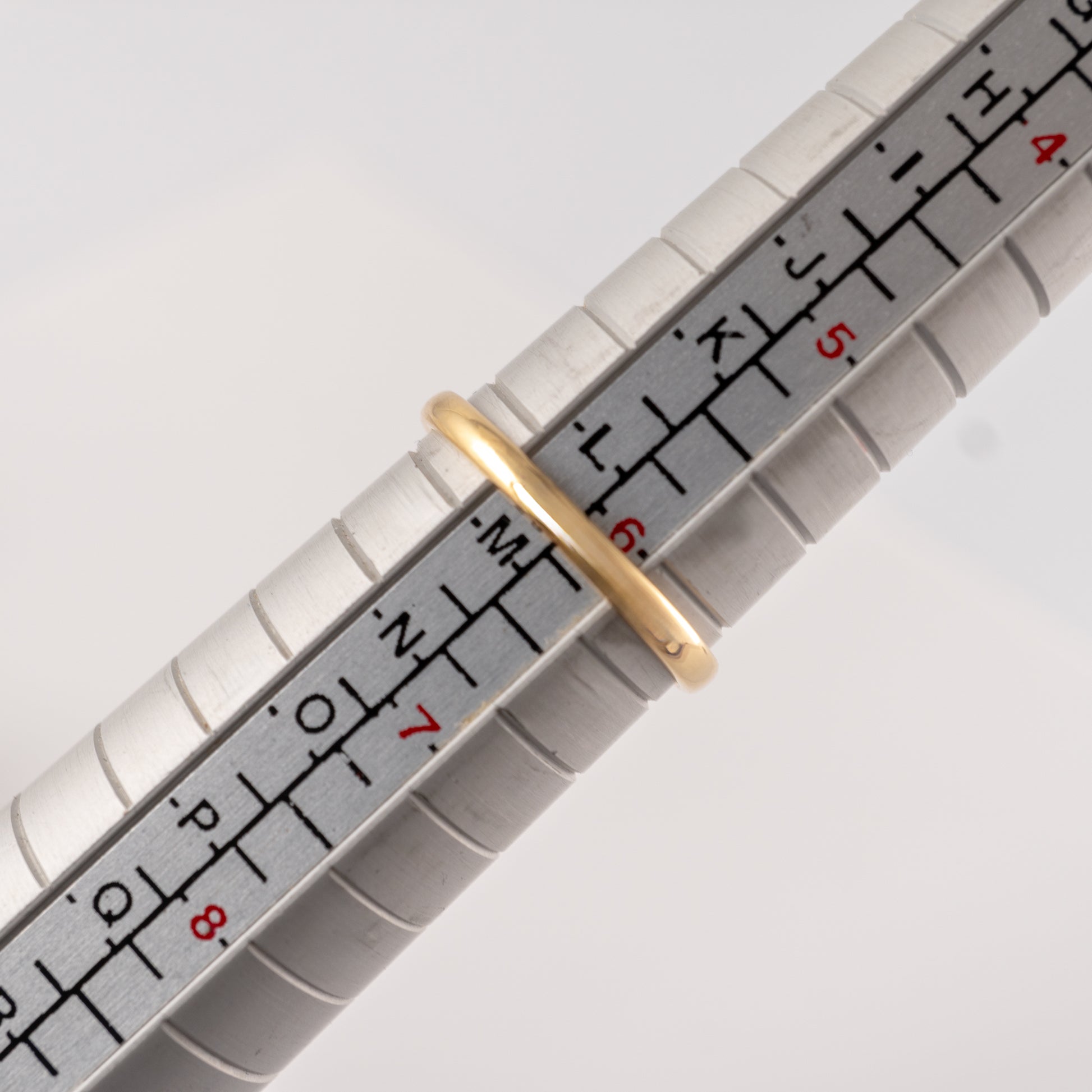 Vintage 18ct gold and platinum diamond daisy ring on a ring sizer, illustrating its size – Hunters Fine Jewellery.