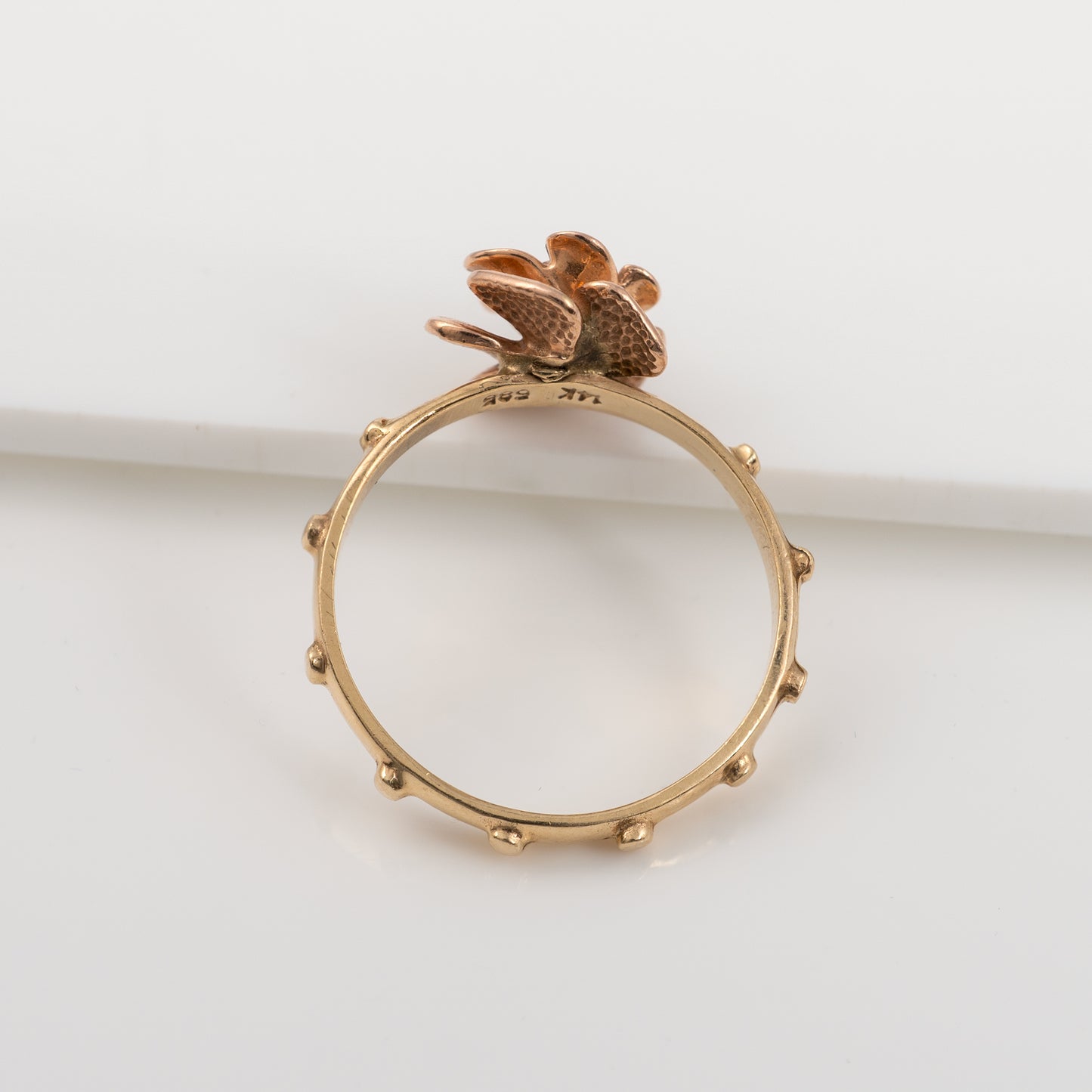 Top view of 14K gold rosary ring showcasing ruby gemstone and prayer nodules