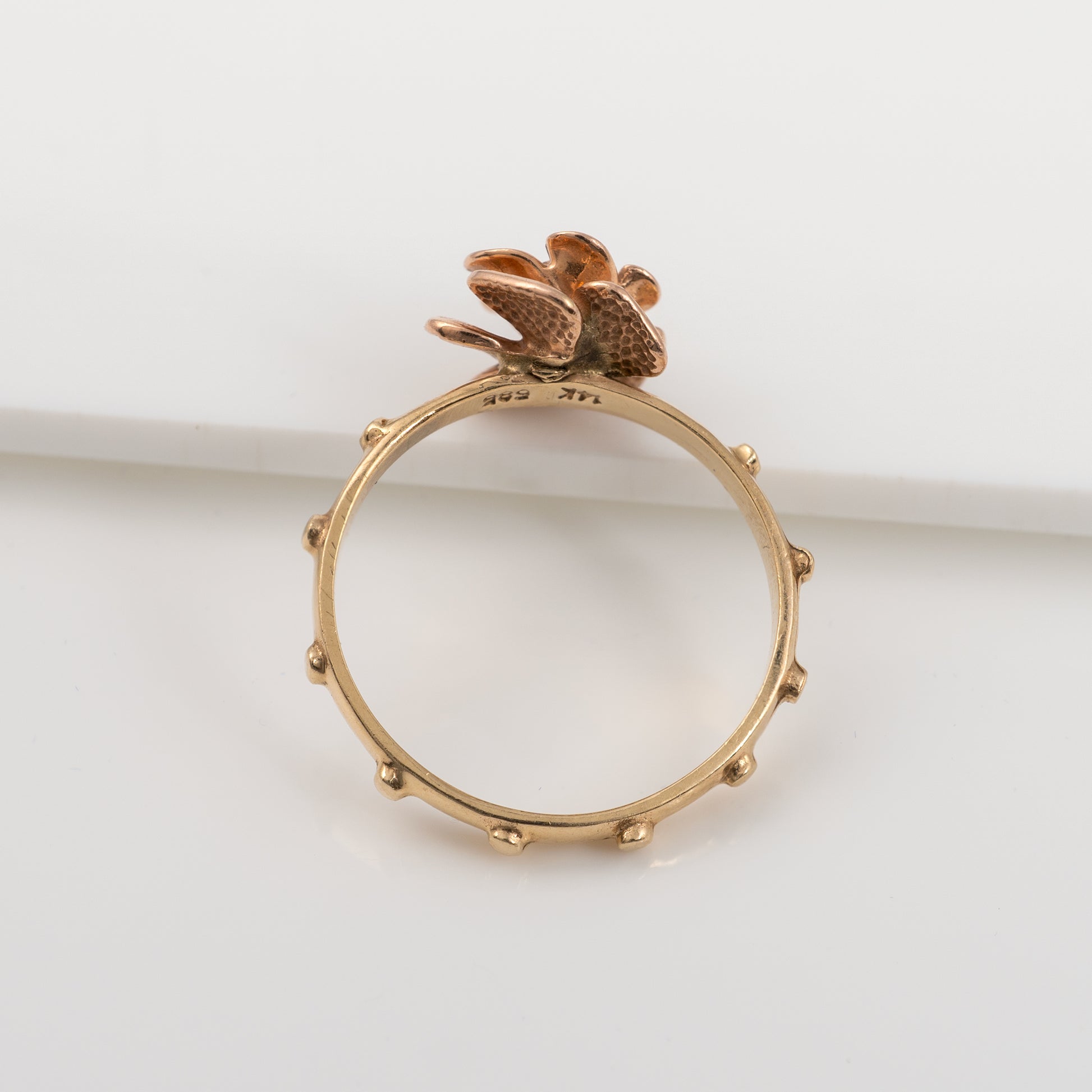 Top view of 14K gold rosary ring showcasing ruby gemstone and prayer nodules