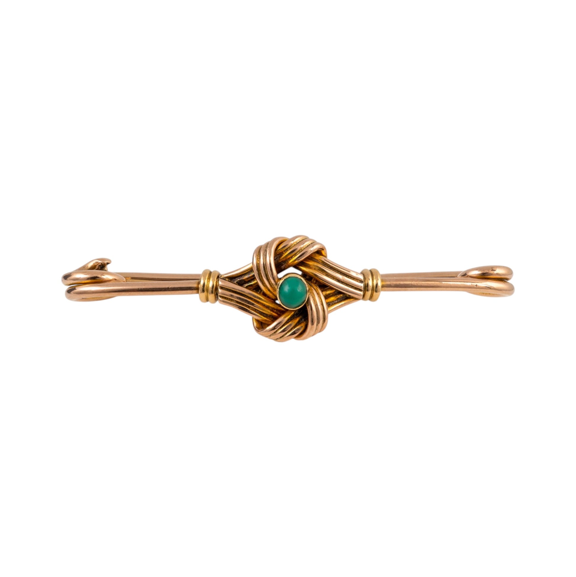 A gold-toned brooch featuring a central knotted wire design with a small oval green stone accent, set against a plain white background.