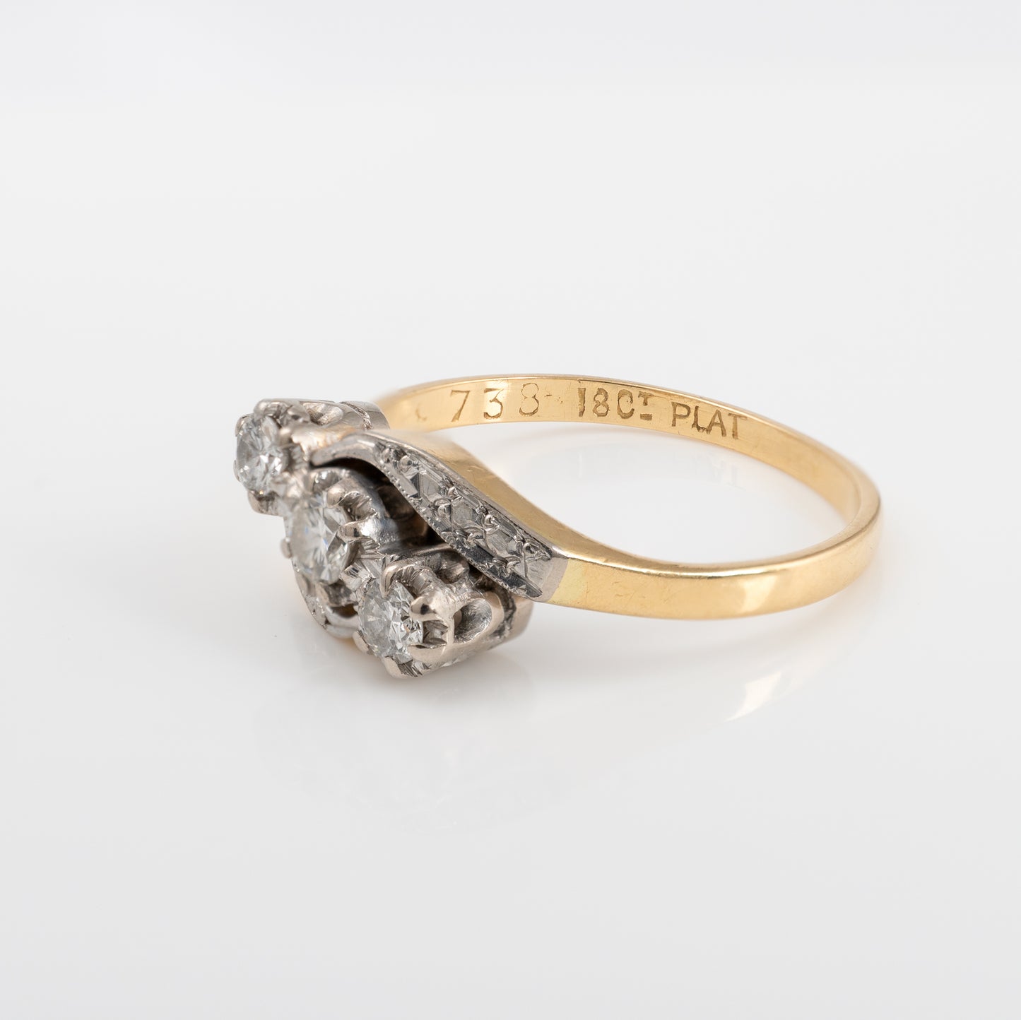 Side view of vintage three stone diamond ring with twist shoulder setting