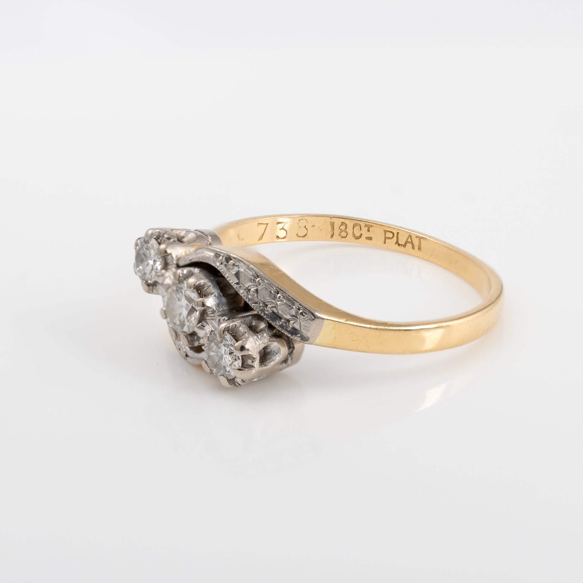 Side view of vintage three stone diamond ring with twist shoulder setting
