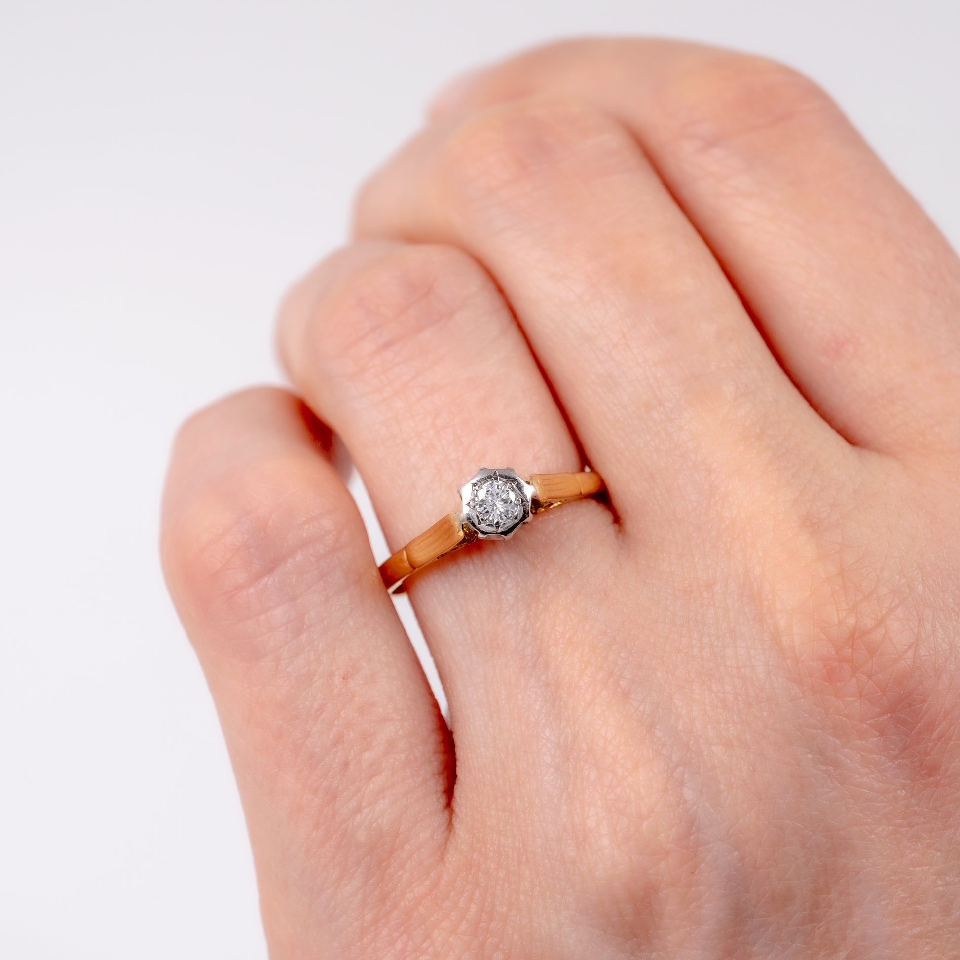 vintage diamond solitaire engagement ring on womans hand