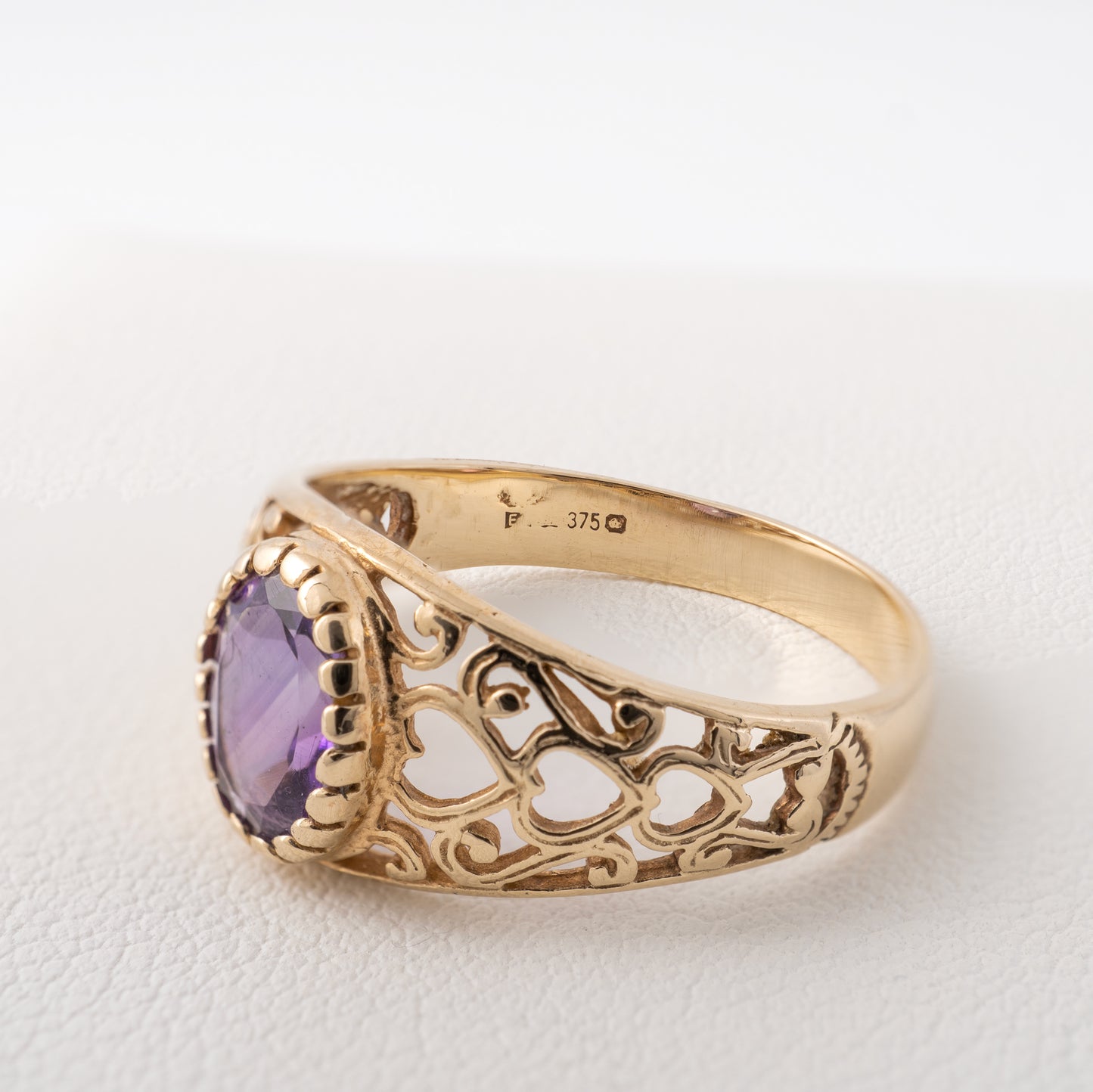 Vintage 9ct gold amethyst ring side view showing hallmarks and intricate heart motif