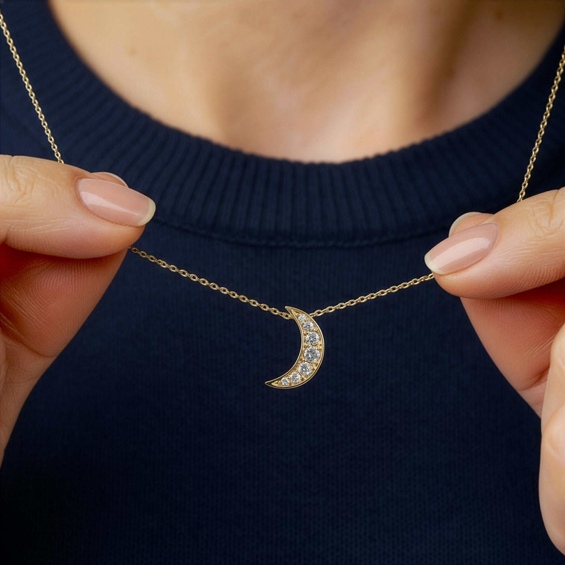 woman holding diamond moon crescent necklace