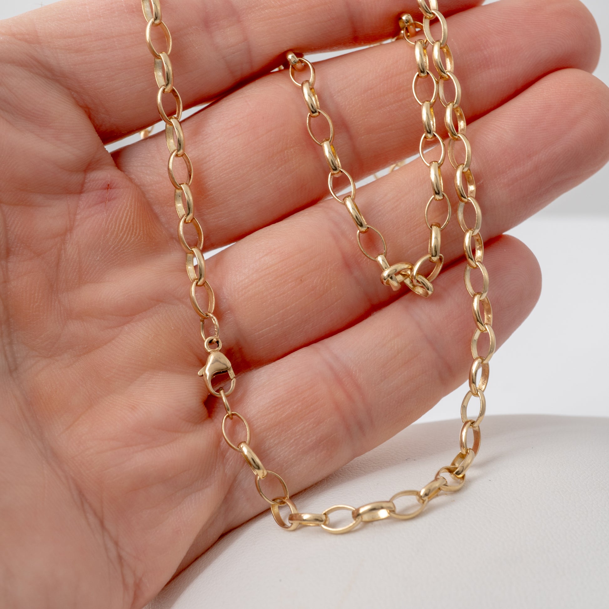 Women's pre-owned 9ct yellow gold belcher chain necklace held in hand to display colour and scale.