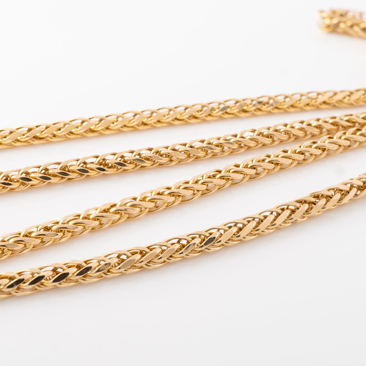 Close-up view of the 9ct gold spiga chain necklace links, showcasing the interwoven braided design