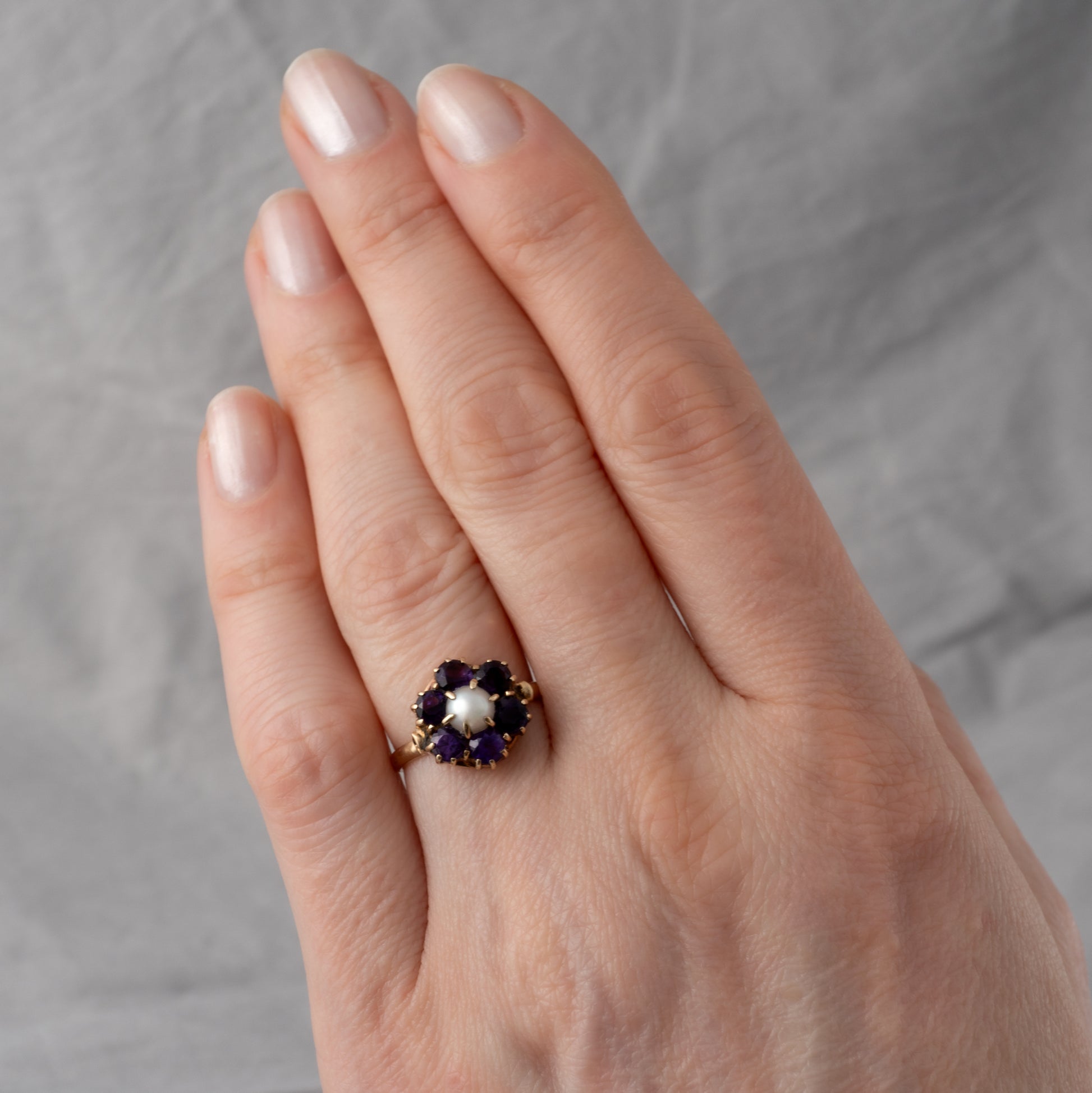 vintage amethyst pearl flower ring worn on womans hand