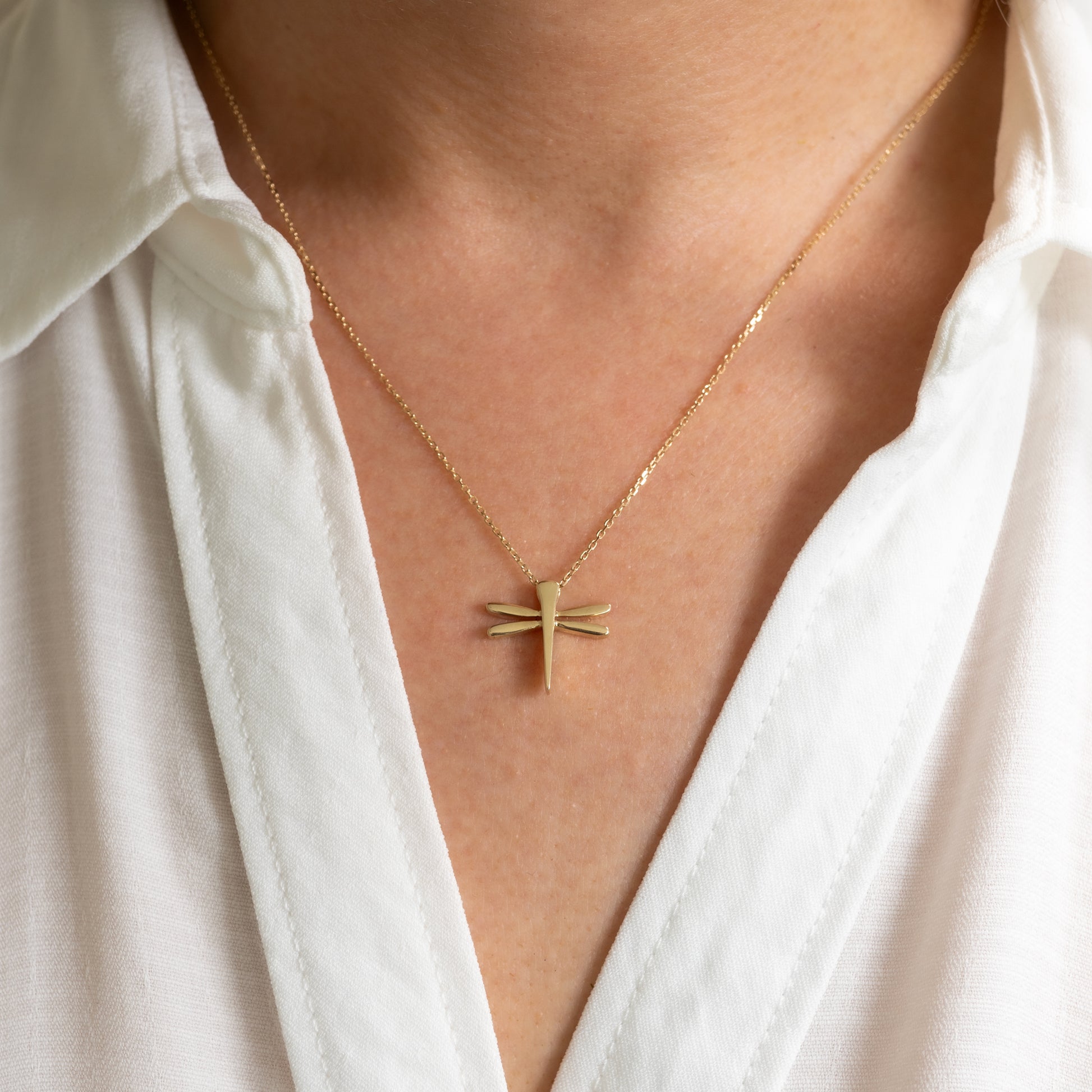 woman wearing gold dragonfly necklace