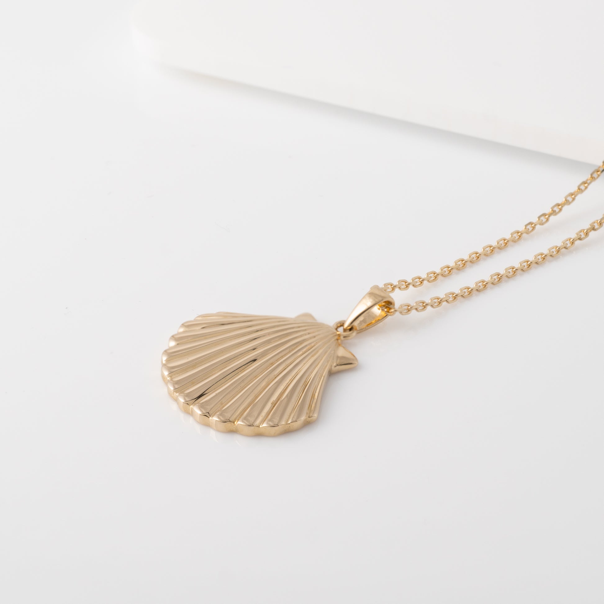 gold shell necklace showing textured front   and thickness