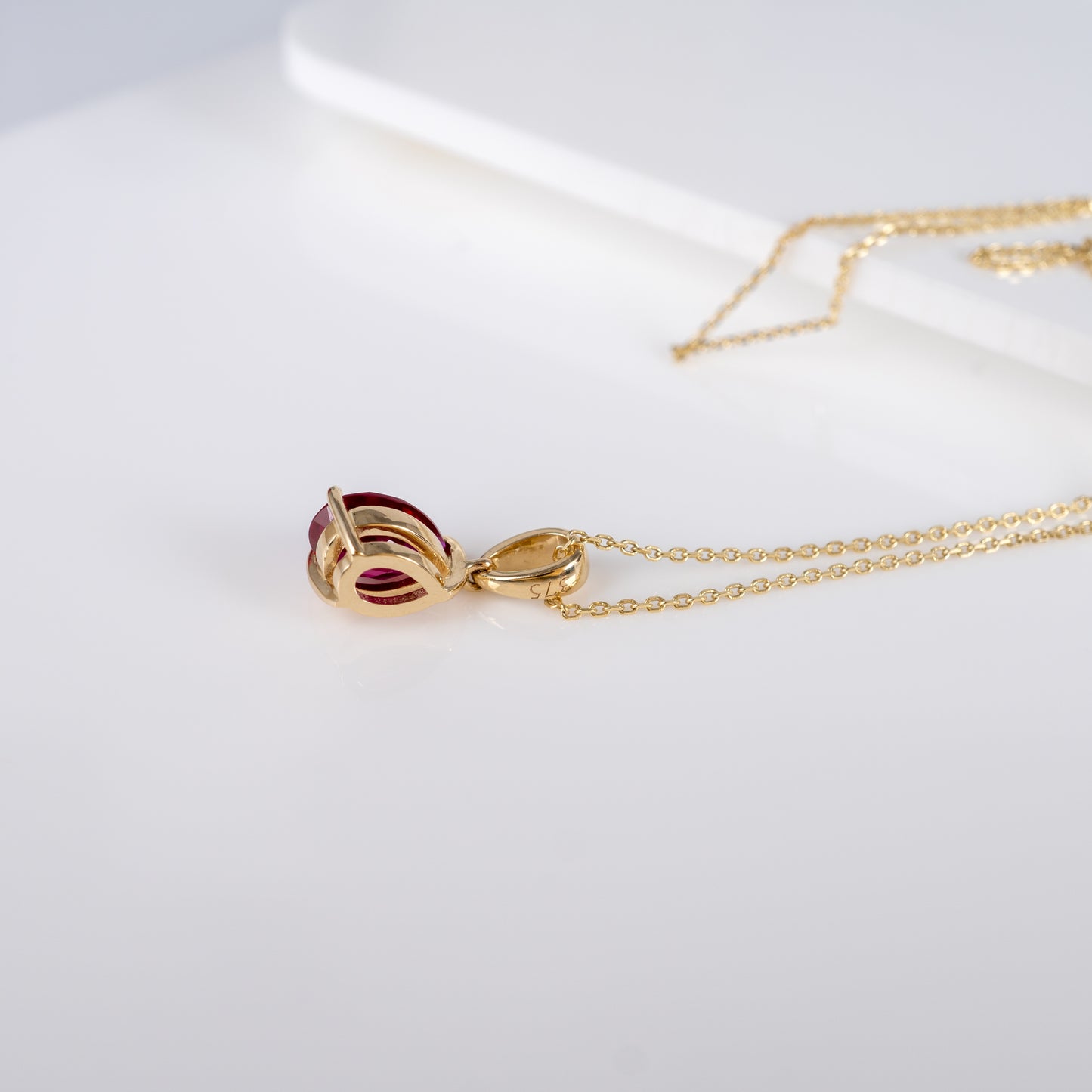 Side view of ruby teardrop pendant necklace in 9ct yellow gold, highlighting lab-grown ruby and pear-shaped design.