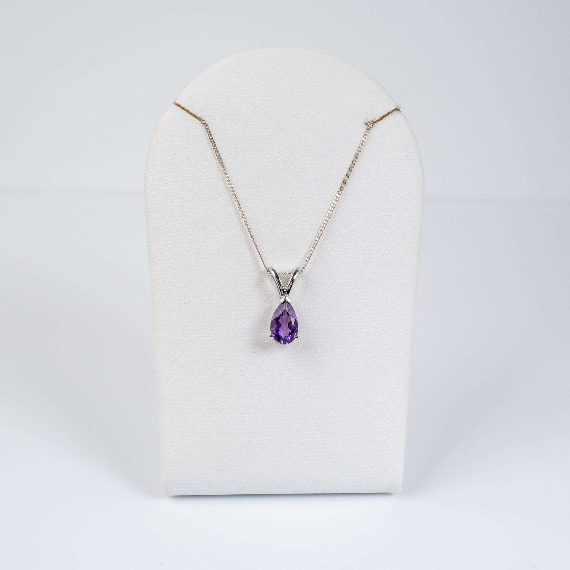 amethyst teardrop necklace pendant o a white display prop